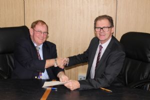Mayor Michael Britten and Mayor Lindsay Brown shake hands after signing the MOU.